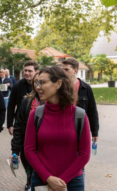 Colleagues walking and talking together along a leafy park path on a mindful walk.