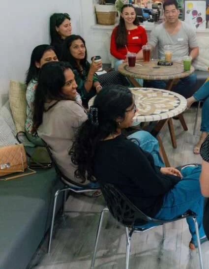 Colleagues laughing together around café tables during a facilitated session
