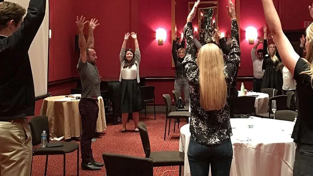 Staff doing chair yoga together in a function room