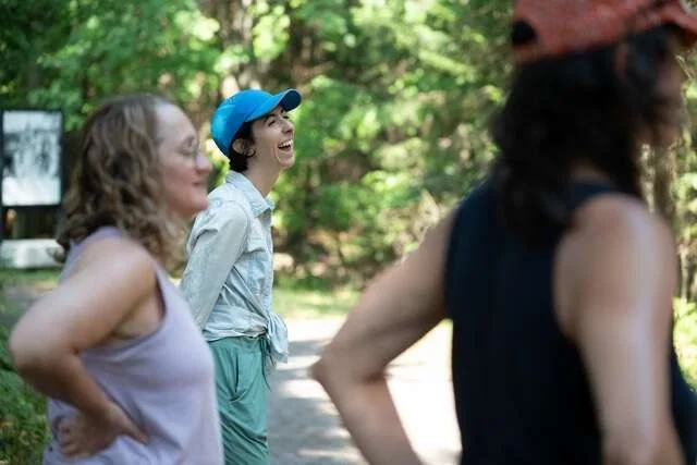 Colleagues laughing together on a woodland path during a guided nature walk