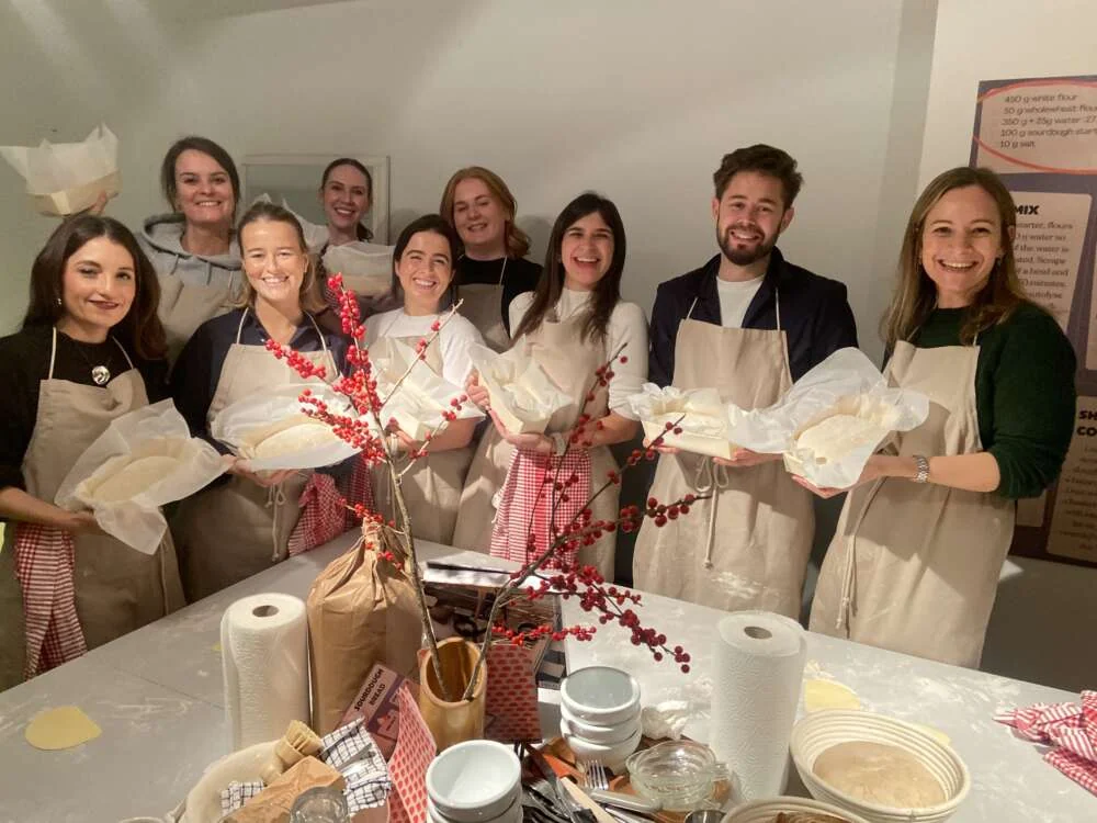 A team holding up the loaves they baked together