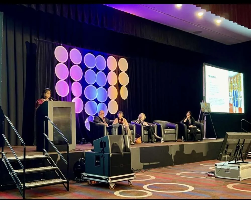 A conference stage set in a ballroom during a collaborative art experience