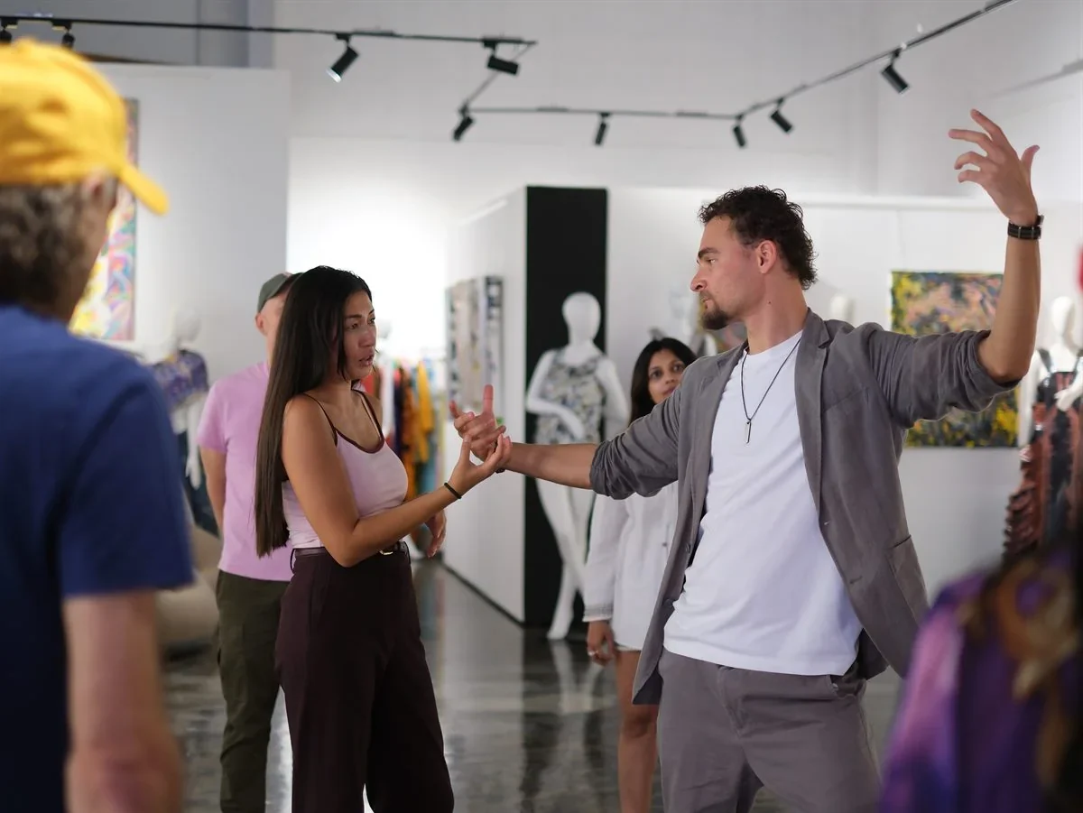 An improvisation session in a Dubai art gallery, a facilitator guiding a participant through an exercise