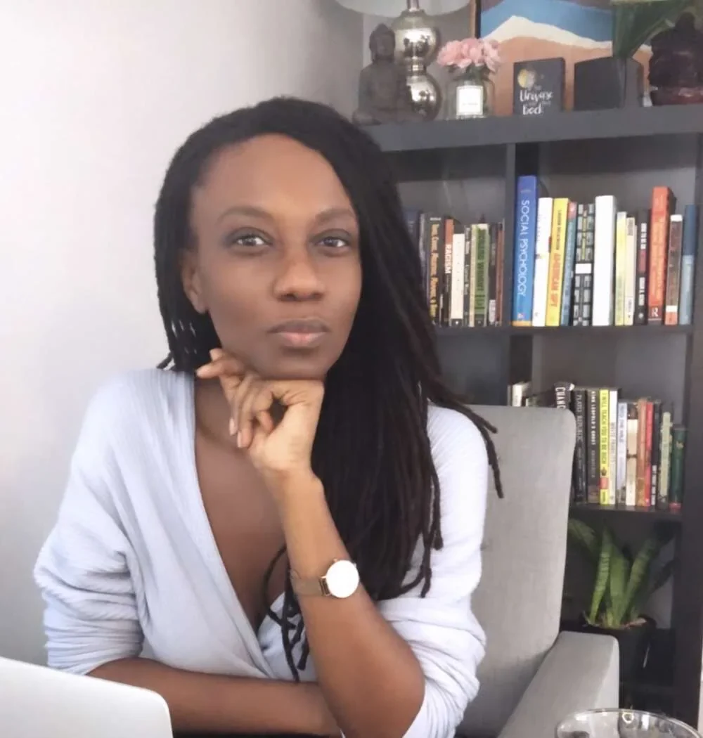 Crystal seated by her bookshelves